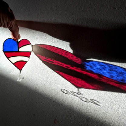 light shining through the stained glass american flag heart suncatcher inside